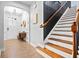 Bright entryway with wood floors and staircase featuring white risers and dark wood handrail at 2069 Brightleaf Way # 123, Marietta, GA 30060