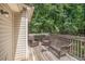 Outdoor back deck featuring a wood deck and railings, and outdoor furniture with surrounding tree views at 300 Alcovy Way, Covington, GA 30014