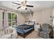Bedroom featuring a ceiling fan, large window with hanging vines, and a cozy chair at 300 Alcovy Way, Covington, GA 30014