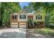Inviting split-level home with stone accents, lush surroundings, two-car garage, and cozy entrance with wooden stairs at 300 Alcovy Way, Covington, GA 30014