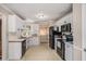 Well-lit kitchen featuring white cabinets, black appliances, and tile flooring at 300 Alcovy Way, Covington, GA 30014