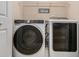 Modern laundry room showcasing a newer model washer and dryer set with overhead shelving at 300 Alcovy Way, Covington, GA 30014