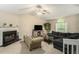 Cozy living room with fireplace, plush sofa, large TV, and a charming chaise lounge, bathed in natural light at 300 Alcovy Way, Covington, GA 30014