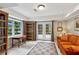 Cozy basement room featuring tile flooring, a vibrant orange sofa, and bright sunlight at 4584 E Conway Nw Dr, Atlanta, GA 30327