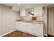 Basement wet bar with white cabinets, neutral countertop, and mirrored backsplash at 4584 E Conway Nw Dr, Atlanta, GA 30327