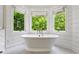 Bright bathroom featuring a luxurious soaking tub beneath a large bay window at 4584 E Conway Nw Dr, Atlanta, GA 30327
