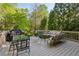 Outdoor deck featuring dining and seating areas, grill, and wooded views at 4584 E Conway Nw Dr, Atlanta, GA 30327
