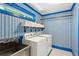 Functional laundry room with patterned wallpaper, sink, and modern washer and dryer at 4584 E Conway Nw Dr, Atlanta, GA 30327