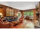 Elegant living room featuring wood paneling, a stone fireplace, and natural light from large windows at 4584 E Conway Nw Dr, Atlanta, GA 30327