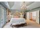 Serene main bedroom with a tray ceiling, french doors, sitting area, and walk-in closet at 4584 E Conway Nw Dr, Atlanta, GA 30327