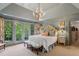 Spacious main bedroom with tray ceiling, French doors to balcony, ensuite bath, and custom floral touches at 4584 E Conway Nw Dr, Atlanta, GA 30327