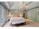 Spacious main bedroom with a tray ceiling, carpet floors, and floral patterned decorations at 4584 E Conway Nw Dr, Atlanta, GA 30327