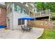 Back patio and outdoor dining area with natural stone retaining wall and upper deck at 4584 E Conway Nw Dr, Atlanta, GA 30327