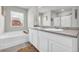Bright bathroom with double sink vanity, framed mirror, and soaking tub at 509 Azalea Bloom Dr, Loganville, GA 30052