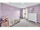 Bedroom featuring a lilac wall color, dresser, and plush decor, offering a cozy retreat at 509 Azalea Bloom Dr, Loganville, GA 30052