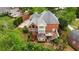 Aerial view of a stunning brick home with deck, lush landscaping, and a private backyard retreat at 6020 Ettington Dr, Suwanee, GA 30024