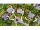 A neighborhood aerial view features mature trees, winding streets and driveways, and large homes, some with pools at 6020 Ettington Dr, Suwanee, GA 30024