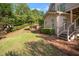 Backyard featuring well-maintained lawn, lush greenery, patio, and a serene outdoor space at 6020 Ettington Dr, Suwanee, GA 30024