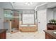Bright bathroom features a soaking tub, glass shower, and granite countertops at 6020 Ettington Dr, Suwanee, GA 30024