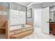 Well-lit bathroom showcasing a soaking tub with decorative tile and a separate shower area at 6020 Ettington Dr, Suwanee, GA 30024
