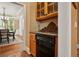 Butler's pantry with wood cabinets, dark countertops, and adjacent dining area offers convenient serving and storage at 6020 Ettington Dr, Suwanee, GA 30024