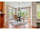 Bright dining area with large windows, elegant chandelier, and hardwood floors at 6020 Ettington Dr, Suwanee, GA 30024