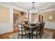 Dining room view with staircase. The room features wainscoting, hardwood floors, and modern chandelier at 6020 Ettington Dr, Suwanee, GA 30024
