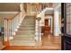A grand foyer with hardwood and carpeted stairs, adjacent to a light-filled space, welcomes visitors at 6020 Ettington Dr, Suwanee, GA 30024