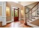 Grand foyer featuring hardwood floors, a decorative glass front door, and a staircase with white risers at 6020 Ettington Dr, Suwanee, GA 30024