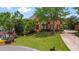 Attractive brick home with manicured lawn, mature trees, and a circular driveway for easy access at 6020 Ettington Dr, Suwanee, GA 30024