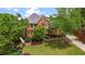 Beautiful brick home with lush landscaping, mature trees, and a well-maintained lawn at 6020 Ettington Dr, Suwanee, GA 30024