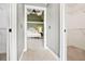 Hallway leading to the main bedroom and walk-in closet in a neutral color palette at 6020 Ettington Dr, Suwanee, GA 30024