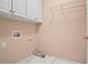 The laundry room has built-in cabinets above and a hanging rack, and white tiled floors at 6020 Ettington Dr, Suwanee, GA 30024