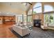 Open-concept living room with fireplace, large windows, and hardwood flooring at 6020 Ettington Dr, Suwanee, GA 30024