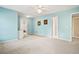 Spacious main bedroom painted in light blue with carpet floor and ensuite bathroom at 6020 Ettington Dr, Suwanee, GA 30024