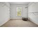 Spacious walk-in closet with carpeted floor, shelving, and center table with window at 6020 Ettington Dr, Suwanee, GA 30024