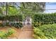 Landscaped entryway with garden path leading to a wrought iron gate, enhancing curb appeal at 677 Somerset Ne Ter # C6, Atlanta, GA 30306