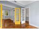 Bright living room boasts hardwood floors, transom windows, and unique yellow French doors at 677 Somerset Ne Ter # C6, Atlanta, GA 30306