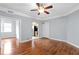 Open-concept living room features wood floors, ceiling fan, arched doorway to kitchen, and natural light at 677 Somerset Ne Ter # C6, Atlanta, GA 30306