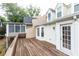 View of the wooden back deck featuring white trim with direct access to the house and a covered porch at 911 Lenox Hill Ne Ct, Atlanta, GA 30324