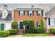 Charming brick townhouse featuring black shutters, well-manicured landscaping, and welcoming front entrance at 911 Lenox Hill Ne Ct, Atlanta, GA 30324
