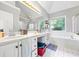 Bright bathroom with a double sink vanity, a tub, a shower, and a large window at 115 Stonewall Dr, Covington, GA 30016