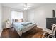 Bright bedroom featuring hardwood floors, a ceiling fan, and a comfortable bed at 115 Stonewall Dr, Covington, GA 30016