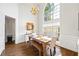 Dining room with hardwood floors, a modern chandelier and a large window providing natural light at 115 Stonewall Dr, Covington, GA 30016