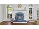 Close up of the fireplace with dark green hearth, white mantle, and decorative iron fire screen at 115 Stonewall Dr, Covington, GA 30016