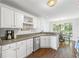Eat-in kitchen features wood flooring and white cabinetry with stainless steel appliances at 115 Stonewall Dr, Covington, GA 30016