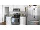 Galley kitchen featuring stainless steel appliances and white cabinetry at 115 Stonewall Dr, Covington, GA 30016