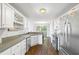 Bright kitchen features white cabinets, stainless steel appliances, and hardwood floors at 115 Stonewall Dr, Covington, GA 30016