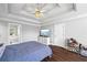 Bedroom features wood flooring, tray ceilings, and en suite bathroom at 115 Stonewall Dr, Covington, GA 30016