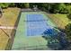 A well-maintained tennis court surrounded by green grass and lush trees, perfect for recreation and exercise at 115 Stonewall Dr, Covington, GA 30016
